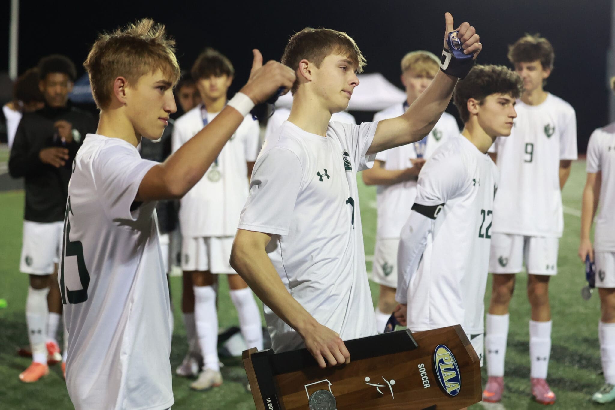 Senior captains Brecon Williams (left) and Jude Sacks give a thumbs up to the crowd after collecting the PIAA Class A runner up trophy on November 15, 2025