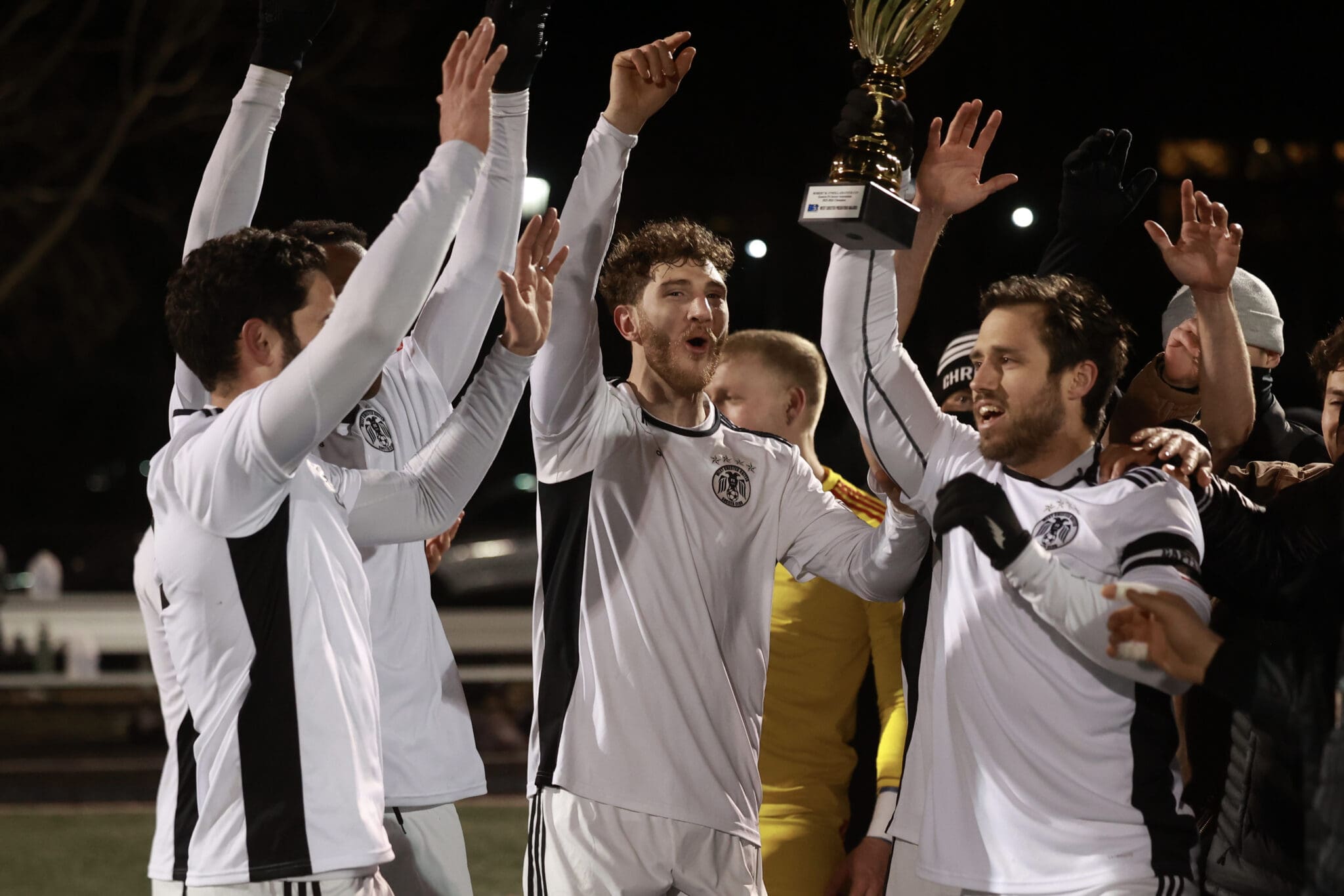 West Chester United captain Ridge Robinson and teammates celebrate with the EPSA Amateur Cup trophy after a 4-3 win over Vereinigung Erzgebirge on March 13, 2026. Photo by Matthew Ralph.